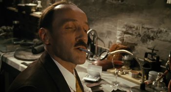 Movie still from “The Counterfeiters” (2007), directed by Stefan Ruzowitzky – A man in a suit and tie drinking wine; Close Up shot, Low angle
