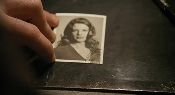 Movie still from “The Counterfeiters” (2007), directed by Stefan Ruzowitzky – A person holding an old photo of a woman; Extreme Close Up shot, High angle