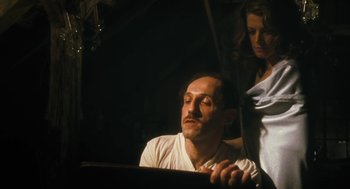 Movie still from “The Counterfeiters” (2007), directed by Stefan Ruzowitzky – A man and a woman are sitting in a dark room; Medium shot, Low angle