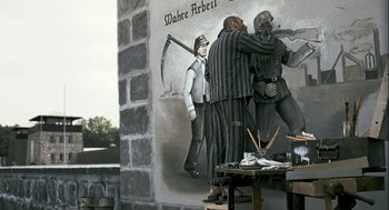 Movie still from “The Counterfeiters” (2007), directed by Stefan Ruzowitzky – A painting of two men fighting in front of a building; Wide shot, Over the shoulder angle