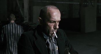 Movie still from “The Counterfeiters” (2007), directed by Stefan Ruzowitzky – A man smoking a cigarette while sitting down; Close Up shot, Low angle