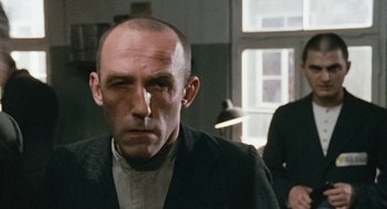 Movie still from “The Counterfeiters” (2007), directed by Stefan Ruzowitzky – A person wearing a suit and tie; Close Up shot, Over the shoulder angle