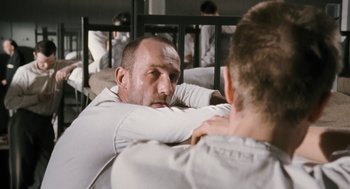 Movie still from “The Counterfeiters” (2007), directed by Stefan Ruzowitzky – A man sitting next to another man on a bed; Close Up shot, Over the shoulder angle