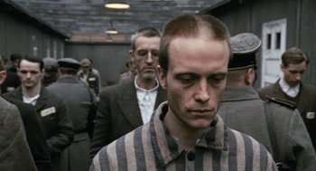 Movie still from “The Counterfeiters” (2007), directed by Stefan Ruzowitzky – A group of men standing next to each other in a building; Medium shot, Over the shoulder angle