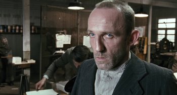 Movie still from “The Counterfeiters” (2007), directed by Stefan Ruzowitzky – A person wearing a suit and tie; Close Up shot, Low angle