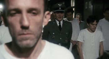 Movie still from “The Counterfeiters” (2007), directed by Stefan Ruzowitzky – A group of men standing next to each other in a room; Close Up shot, Over the shoulder angle