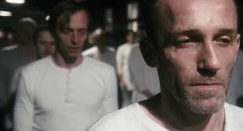 Movie still from “The Counterfeiters” (2007), directed by Stefan Ruzowitzky – A man in a white shirt is looking at the camera; Close Up shot, Over the shoulder angle
