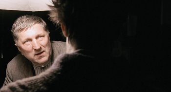 Movie still from “The Counterfeiters” (2007), directed by Stefan Ruzowitzky – An older man looking in the mirror while standing up; Close Up shot, Over the shoulder angle