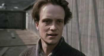 Movie still from “The Counterfeiters” (2007), directed by Stefan Ruzowitzky – A person wearing a sweater; Close Up shot, Low angle