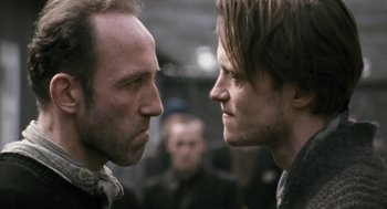 Movie still from “The Counterfeiters” (2007), directed by Stefan Ruzowitzky – Two men face each other in a fight; Close Up shot, Over the shoulder angle