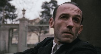 Movie still from “The Counterfeiters” (2007), directed by Stefan Ruzowitzky – A person wearing a suit and tie; Close Up shot, Low angle