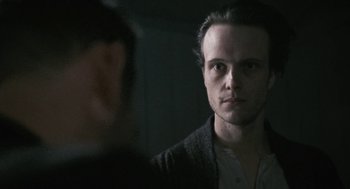 Movie still from “The Counterfeiters” (2007), directed by Stefan Ruzowitzky – A man in a dark room looking into a mirror; Close Up shot, Over the shoulder angle