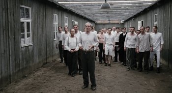 Movie still from “The Counterfeiters” (2007), directed by Stefan Ruzowitzky – A large group of men standing in front of a building; Wide shot, High angle