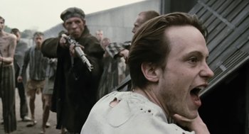 Movie still from “The Counterfeiters” (2007), directed by Stefan Ruzowitzky – A group of men standing next to each other holding guns; Close Up shot, Over the shoulder angle