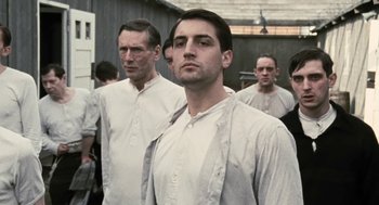 Movie still from “The Counterfeiters” (2007), directed by Stefan Ruzowitzky – A group of men standing next to each other in white shirts; Medium shot, Low angle
