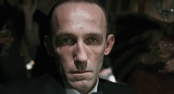 Movie still from “The Counterfeiters” (2007), directed by Stefan Ruzowitzky – A person wearing a suit and tie; Close Up shot, Low angle