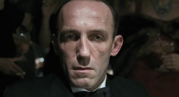 Movie still from “The Counterfeiters” (2007), directed by Stefan Ruzowitzky – A person wearing a suit and tie; Close Up shot, Low angle