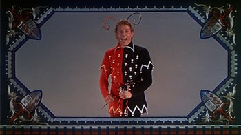 Movie still from “The Court Jester” (1955), directed by Melvin Frank – A man dressed as a jester in a black and red outfit; Medium shot, Low angle