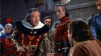 Movie still from “The Court Jester” (1955), directed by Melvin Frank – A group of men standing next to each other in a room; Medium shot, Over the shoulder angle