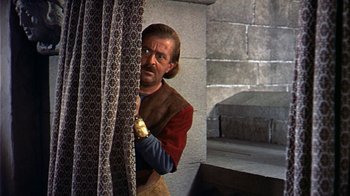 Movie still from “The Court Jester” (1955), directed by Melvin Frank – A man standing in front of a curtain; Medium shot, Low angle