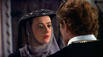 Movie still from “The Court Jester” (1955), directed by Melvin Frank – A woman wearing a hat and a veil talking to another woman; Close Up shot, Over the shoulder angle