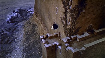 Movie still from “The Court Jester” (1955), directed by Melvin Frank – A man is climbing up the side of a castle wall; Extreme Wide shot, High angle