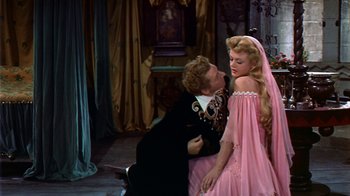 Movie still from “The Court Jester” (1955), directed by Melvin Frank – A man and a woman dressed in pink and black are kissing; Medium shot, Over the shoulder angle