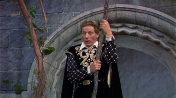 Movie still from “The Court Jester” (1955), directed by Melvin Frank – A man dressed in black and white holding a stick; Medium shot, Low angle