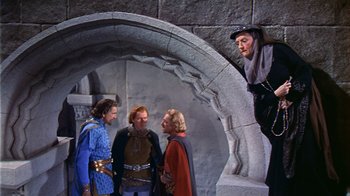 Movie still from “The Court Jester” (1955), directed by Melvin Frank – A group of men standing around a stone arch; Wide shot, Over the shoulder angle