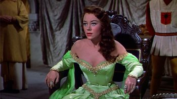 Movie still from “The Court Jester” (1955), directed by Melvin Frank – A woman in a green dress sitting on a chair; Medium shot, High angle