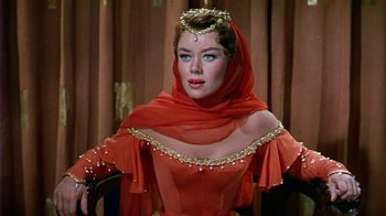 Movie still from “The Court Jester” (1955), directed by Melvin Frank – A woman wearing a red dress and a gold headpiece; Close Up shot, Over the shoulder angle