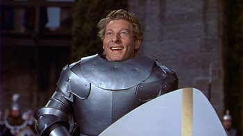 Movie still from “The Court Jester” (1955), directed by Melvin Frank – A man wearing a suit of armor smiles for the camera; Medium shot, Low angle