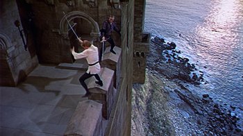 Movie still from “The Court Jester” (1955), directed by Melvin Frank – Two men are fighting on a wall by the water; Wide shot, High angle