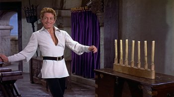 Movie still from “The Court Jester” (1955), directed by Melvin Frank – A man standing in front of a bunch of lit candles; Medium shot, Low angle