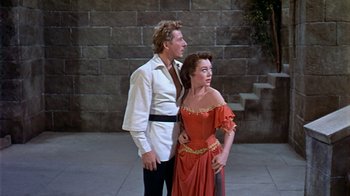 Movie still from “The Court Jester” (1955), directed by Melvin Frank – A man standing next to a woman wearing a red dress; Medium shot, Low angle