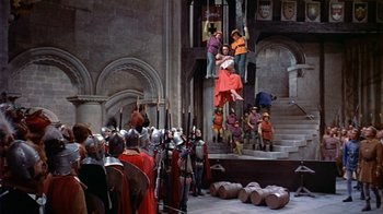Movie still from “The Court Jester” (1955), directed by Melvin Frank – A group of people standing around a building; Extreme Wide shot, High angle