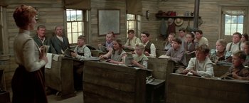 Movie still from “The Cowboys” (1972), directed by Mark Rydell – A group of people sitting in a room; Wide shot, High angle
