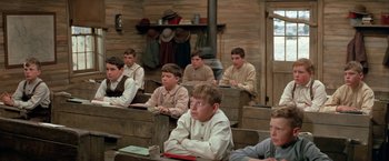 Movie still from “The Cowboys” (1972), directed by Mark Rydell – A group of young men sitting in a room; Medium shot, High angle
