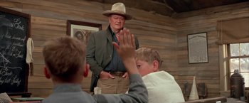 Movie still from “The Cowboys” (1972), directed by Mark Rydell – An older man wearing a hat and a jacket; Medium shot, Over the shoulder angle