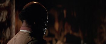 Movie still from “The Cowboys” (1972), directed by Mark Rydell – A man with a face paint is in the dark; Close Up shot, Low angle