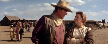 Movie still from “The Cowboys” (1972), directed by Mark Rydell – A man and a woman wearing cowboy hats; Medium shot, Over the shoulder angle