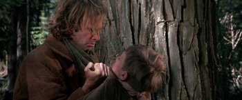 Movie still from “The Cowboys” (1972), directed by Mark Rydell – A man and a boy are fighting in a forest; Close Up shot, Over the shoulder angle