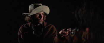 Movie still from “The Cowboys” (1972), directed by Mark Rydell – A man wearing a cowboy hat is talking to someone; Close Up shot, Low angle