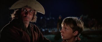 Movie still from “The Cowboys” (1972), directed by Mark Rydell – A man and a boy in cowboy hats looking at each other; Close Up shot, Over the shoulder angle