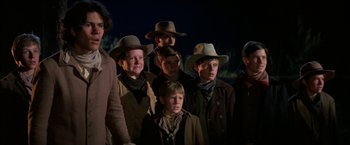 Movie still from “The Cowboys” (1972), directed by Mark Rydell – A group of young men standing next to each other wearing hats; Medium shot, Low angle