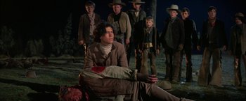 Movie still from “The Cowboys” (1972), directed by Mark Rydell – A group of people standing next to each other on the ground; Medium shot, Low angle