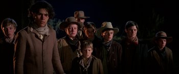 Movie still from “The Cowboys” (1972), directed by Mark Rydell – A group of young men in cowboy hats and coats; Medium shot, Low angle