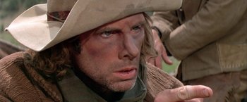 Movie still from “The Cowboys” (1972), directed by Mark Rydell – A person wearing a cowboy hat; Close Up shot, Low angle