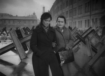 Movie still from “The Cranes Are Flying” (1957), directed by Mikhail Kalatozov – Two women standing next to each other on a street; Medium shot, High angle