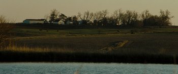 Movie still from “The Crazies” (2010), directed by Breck Eisner – A view of a field and a body of water; Extreme Wide shot, High angle